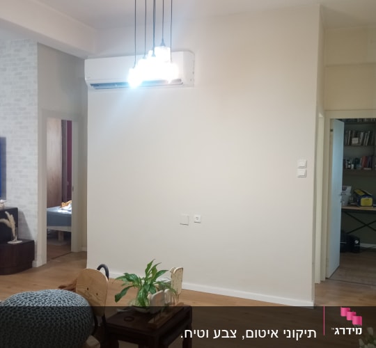 קיר לבן חלק עם תאורה תלויה מעליו